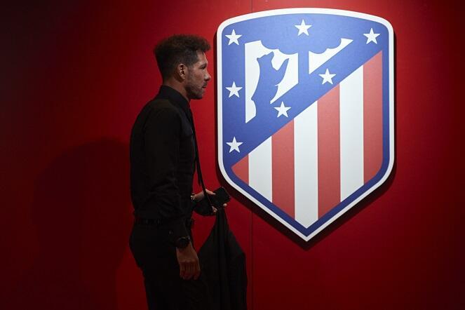Diego Simeone strides past the Atlético Madrid emblem